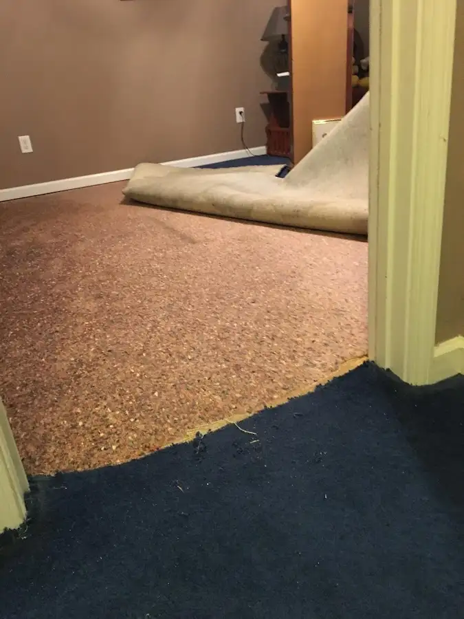 Carpet pad removal revealing water damage during Water Mitigation Services in Storm Lake